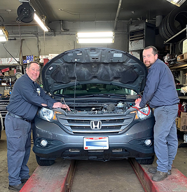 arlington auto mechanics pose with car